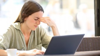 woman with headache working at laptop