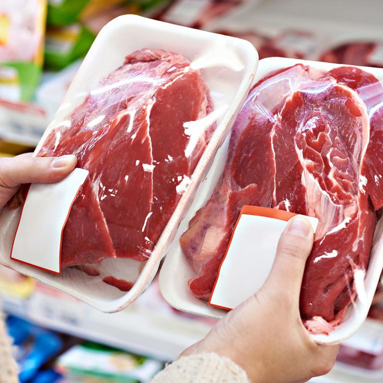 comparing prices of meat at grocery store