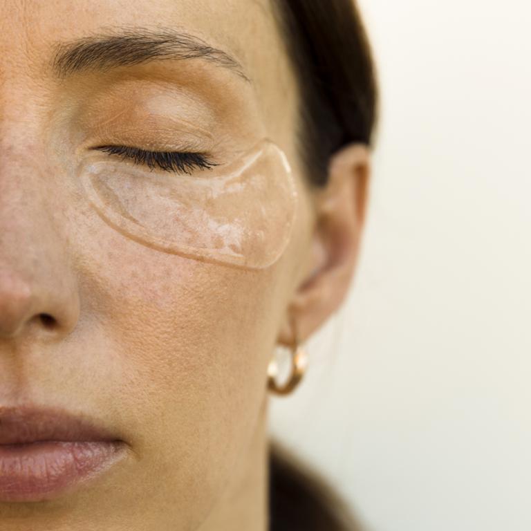 Woman with skincare treatment under eyes