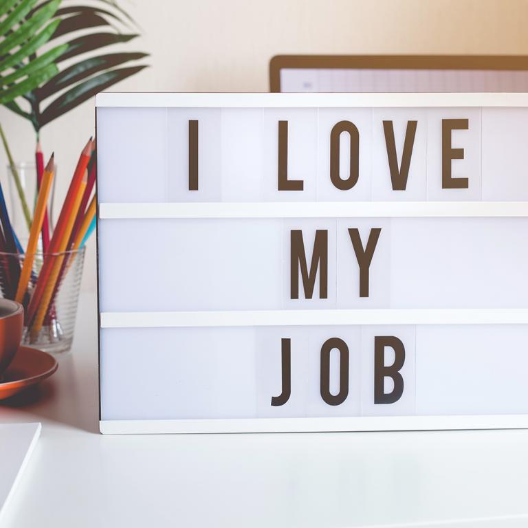sign on desk that says "I love my job"