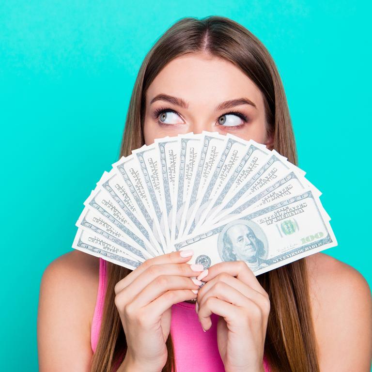 woman holding money in front of her face