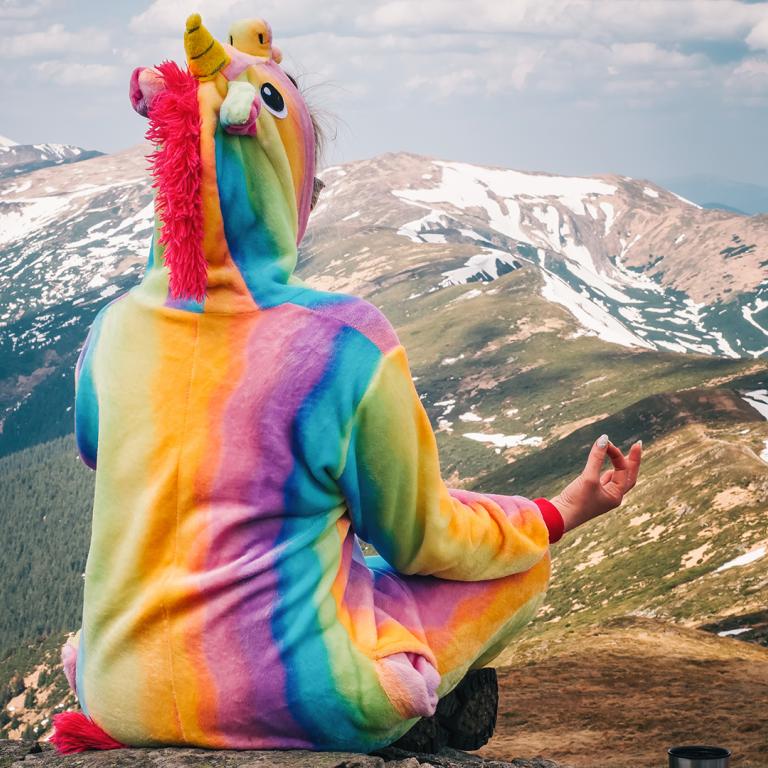 woman wearing unicorn onesie on mountain
