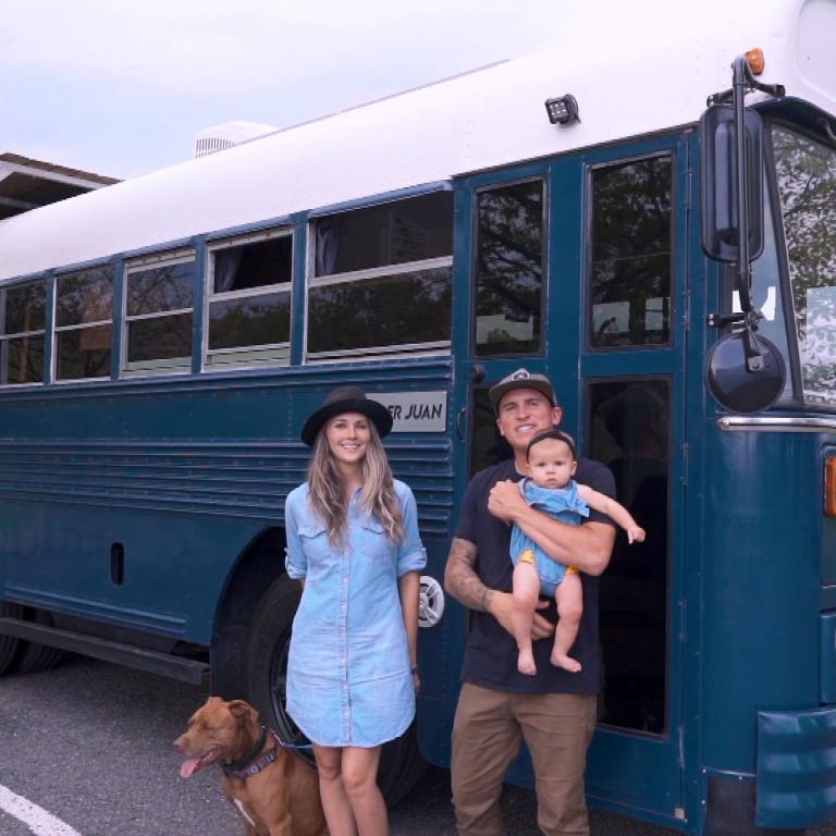 family in front of converted school bus tiny home