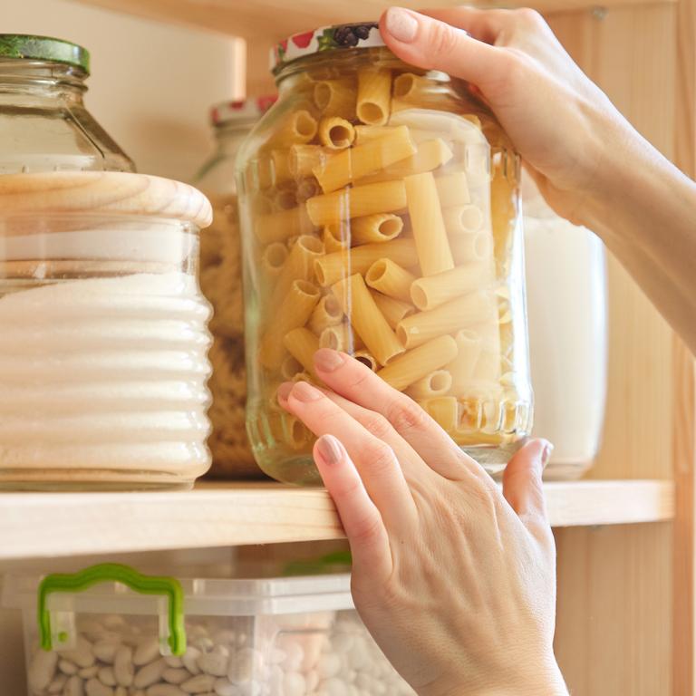 woman taking pasta out of her pantry