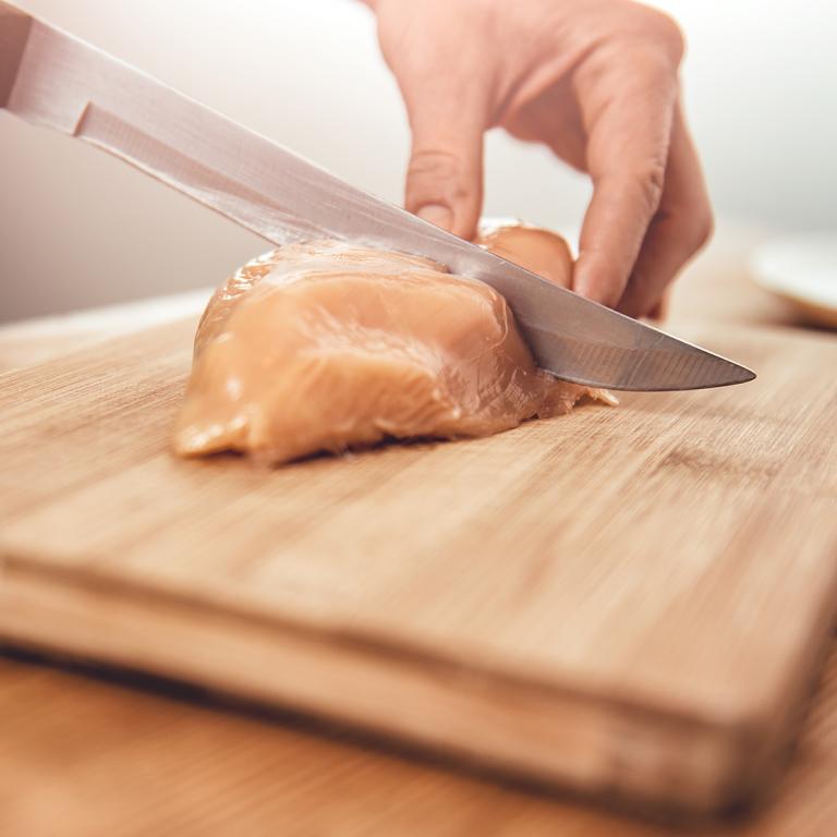 woman slicing into chicken breast