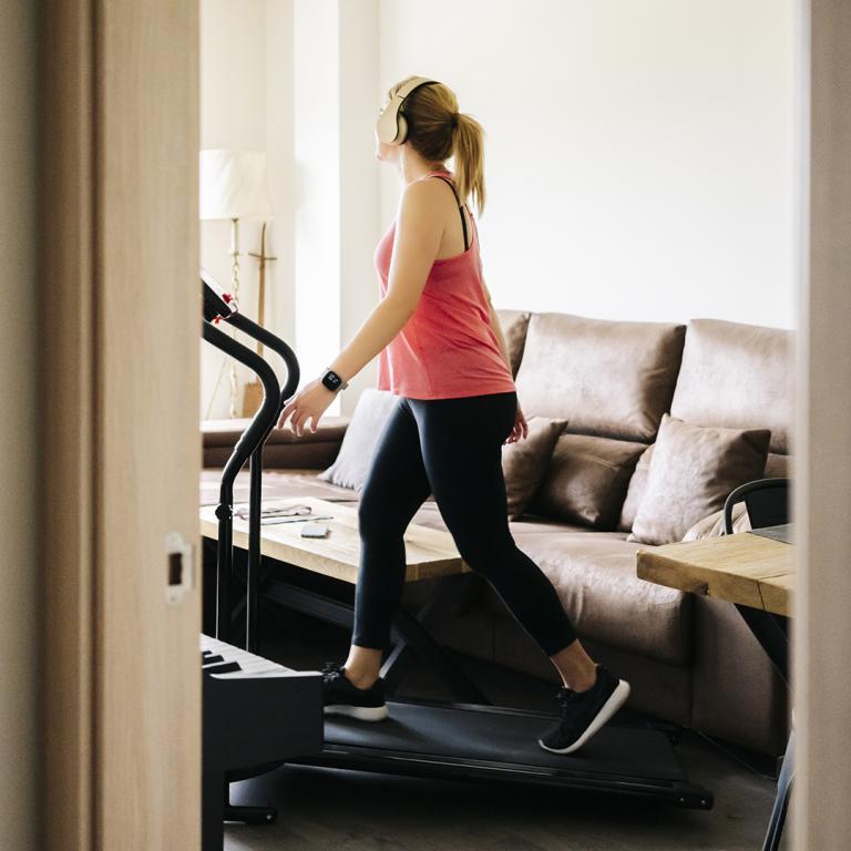 Woman Working Out At Home On Treadmill
