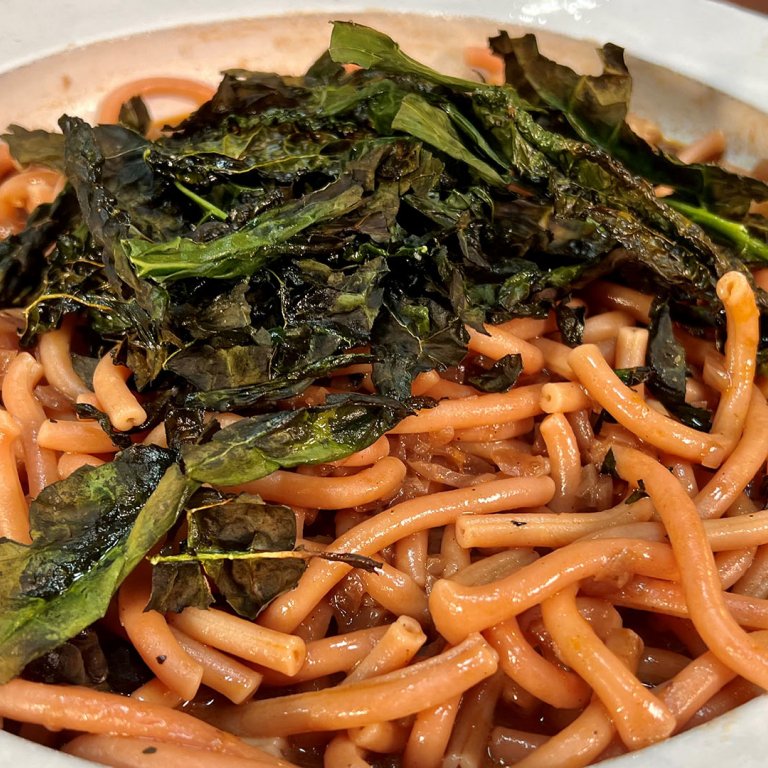 pasta with red onion sauce and crispy kale